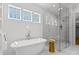 Bright bathroom featuring a standalone tub, glass shower, and marble tile at 2921 Windsor Ave, Charlotte, NC 28209