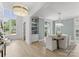 Open-concept dining room featuring light wood floors, a modern chandelier, and expansive windows at 2921 Windsor Ave, Charlotte, NC 28209