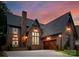 Stunning brick home featuring a large garage, multiple windows, black roof, and a professionally landscaped yard at 2921 Windsor Ave, Charlotte, NC 28209