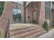 Inviting front entrance with stone steps, a wooden door with glass, and attractive brick and stone facade at 2921 Windsor Ave, Charlotte, NC 28209