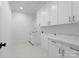 Well-lit laundry room with white cabinets, marble countertops, and stainless steel sink at 2921 Windsor Ave, Charlotte, NC 28209