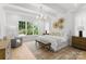 Serene main bedroom with natural light, wood floors, and modern decor with stylish chandelier at 2921 Windsor Ave, Charlotte, NC 28209