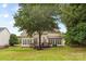 A spacious backyard features a charming deck, and mature trees offering a serene outdoor space at 3213 Strawberry Rd, Matthews, NC 28104