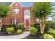 Charming front entrance with a red door, brick facade, and beautifully landscaped walkway at 3213 Strawberry Rd, Matthews, NC 28104