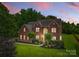 Stunning brick home featuring manicured landscaping, mature trees, and a classic architectural design at 3213 Strawberry Rd, Matthews, NC 28104