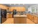 Well-lit kitchen featuring wooden cabinets, granite countertops, a kitchen island and modern appliances at 3213 Strawberry Rd, Matthews, NC 28104