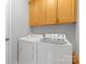 Efficient laundry room with modern washer and dryer, and upper cabinet storage at 3213 Strawberry Rd, Matthews, NC 28104