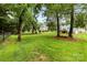 Sprawling backyard with mature trees, a well-maintained lawn, and privacy fencing at 328 Pamela St, Gastonia, NC 28054