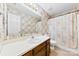 Well-lit bathroom with floral wallpaper, a vanity, and a shower-tub combo with a floral curtain at 328 Pamela St, Gastonia, NC 28054