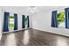 Bright bedroom with hardwood floors, three windows with blue curtains, and a ceiling fan at 328 Pamela St, Gastonia, NC 28054