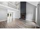 Open-concept living room with modern floors, a cozy fireplace, and bright windows that lead to a deck at 328 Pamela St, Gastonia, NC 28054
