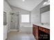 This is a spacious bathroom featuring a large soaking tub, glass-enclosed shower and wood vanity at 3351 Streamside Dr, Davidson, NC 28036