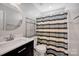This bathroom has a modern sink and vanity, stainless steel fixtures, and a shower with a curtain at 3351 Streamside Dr, Davidson, NC 28036