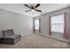 This cozy bedroom includes two windows with pink curtains and a comfortable gray chair at 3351 Streamside Dr, Davidson, NC 28036