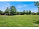 Expansive grassy field with soccer nets and play structures in the distance, framed by trees at 3351 Streamside Dr, Davidson, NC 28036
