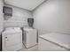 This modern laundry room includes a washer, dryer, folding table and overhead storage at 3351 Streamside Dr, Davidson, NC 28036