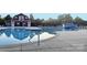 Community pool with kiddie water slide, lounge seating, and a red clubhouse in background at 3351 Streamside Dr, Davidson, NC 28036