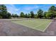 Beautiful tennis courts with well-maintained green surfaces and a pool visible in the background at 3351 Streamside Dr, Davidson, NC 28036