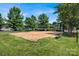 Outdoor sand volleyball court with a sturdy net and a bench, surrounded by green grass at 3351 Streamside Dr, Davidson, NC 28036
