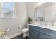 Stylish powder room showcasing a blue vanity, chrome fixtures, and a hardwood floor at 4008 Pinot Way, Fort Mill, SC 29707
