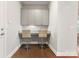 A functional office nook features gray cabinets, granite countertop, and seating for two with hardwood floors at 4008 Pinot Way, Fort Mill, SC 29707