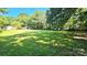 Expansive backyard with mature trees and lush lawn, perfect for outdoor activities and relaxation at 415 S Central Ave, Locust, NC 28097