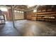 Unfinished basement with exposed brick, shelving, and garage door offers potential for customization at 415 S Central Ave, Locust, NC 28097