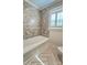 Renovated bathroom with tub, modern tile, and wood-look floor at 415 S Central Ave, Locust, NC 28097
