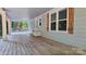 Large covered patio with wood flooring, offering an ideal space for relaxation and enjoying the outdoors at 415 S Central Ave, Locust, NC 28097