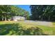 Home with a large driveway, yard, and mature landscaping at 415 S Central Ave, Locust, NC 28097