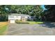 Exterior view of a bright home with ample space for parking and a lush green lawn at 415 S Central Ave, Locust, NC 28097