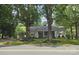 Traditional home with a welcoming front porch, complemented by mature trees and landscaping at 415 S Central Ave, Locust, NC 28097