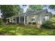 Charming home with light green siding, wooden shutters, and a covered front porch with hanging plants at 415 S Central Ave, Locust, NC 28097