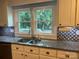 Charming kitchen featuring granite countertops and eye-catching patterned backsplash, under a bright double window at 415 S Central Ave, Locust, NC 28097