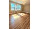 Sunlit living room featuring polished wood floors and a decorative chandelier at 415 S Central Ave, Locust, NC 28097