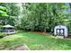 Spacious backyard features lush lawn, mature trees, shed, and wooden deck with gazebo at 488 Saint George Rd, Fort Mill, SC 29708