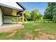 Expansive backyard featuring a covered porch with wooden beams, a ceiling fan, and lush landscaping at 5015 Lancaster Hwy, Monroe, NC 28112