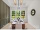 Dining room featuring a wooden table with seating beneath modern lighting and natural light shining through the windows at 5015 Lancaster Hwy, Monroe, NC 28112