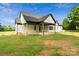 Stunning exterior view of a modern farmhouse-style home with a covered patio and expansive backyard at 5015 Lancaster Hwy, Monroe, NC 28112