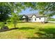 Lush trees frame the exterior of a modern farmhouse with white siding and a well-maintained lawn at 5015 Lancaster Hwy, Monroe, NC 28112
