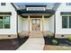 Front entrance featuring brick steps, wooden columns, and a pair of stained wood double doors at 5015 Lancaster Hwy, Monroe, NC 28112