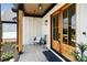 Inviting front porch featuring double doors, a cozy chair, and stylish decor, with wood plank ceiling at 5015 Lancaster Hwy, Monroe, NC 28112