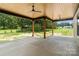 Covered patio with ceiling fans and wooden beams overlooks large yard and provides ample space for outdoor entertaining at 5015 Lancaster Hwy, Monroe, NC 28112