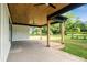 Covered patio area with a wood plank ceiling, ceiling fans, and a view of the expansive, landscaped backyard at 5015 Lancaster Hwy, Monroe, NC 28112