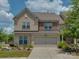 Charming two-story home featuring a stone and brick facade, manicured lawn, and two-car garage at 5020 Forest Hills Pl, Fort Mill, SC 29707