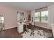 Bright home office with a white desk, modern art, light pink walls and plenty of natural light at 5020 Forest Hills Pl, Fort Mill, SC 29707