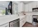 Modern kitchen featuring a white farmhouse sink, stainless steel appliances, and stone countertops at 5020 Forest Hills Pl, Fort Mill, SC 29707