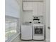 Well-lit laundry room with white cabinets and modern washer and dryer for efficient chores at 5020 Forest Hills Pl, Fort Mill, SC 29707