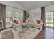 Bright living room with a large sectional couch and open windows offering natural light at 5020 Forest Hills Pl, Fort Mill, SC 29707