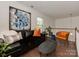 Upstairs living room features a modern black leather sofa and eye-catching blue and white abstract art at 5020 Forest Hills Pl, Fort Mill, SC 29707